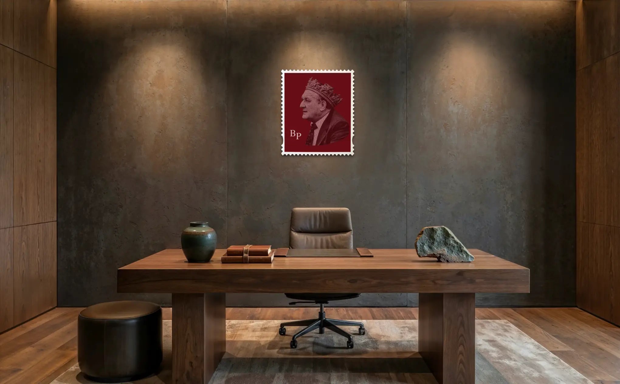 Bob Paisley typography stamp artwork mounted on a textured concrete wall in a dark, moody luxury office, spotlit above a solid walnut desk with leather chair, ceramic vase, stacked books, and a raw stone – a bold centrepiece in a high-end interior. #size_large