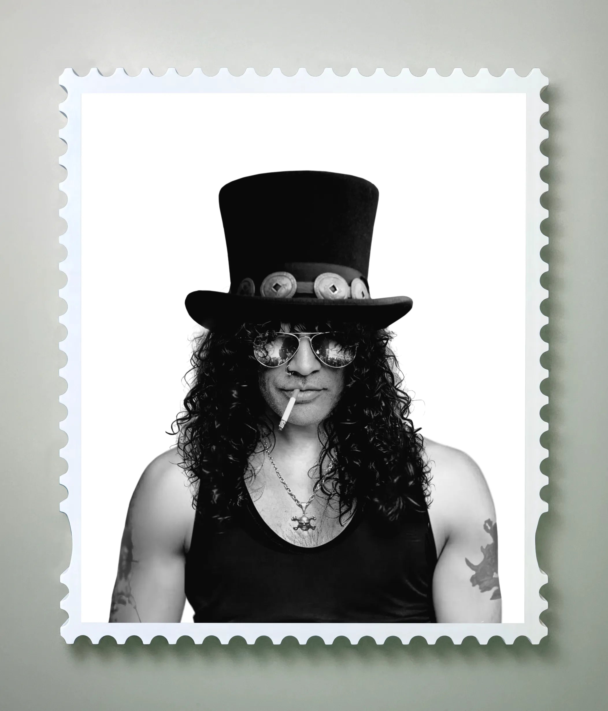 Black and white portrait of Slash in a top hat, aviator sunglasses and curly hair, cigarette at his lips, framed in a postage stamp border against a soft grey background – the portrait state of a lenticular artwork.