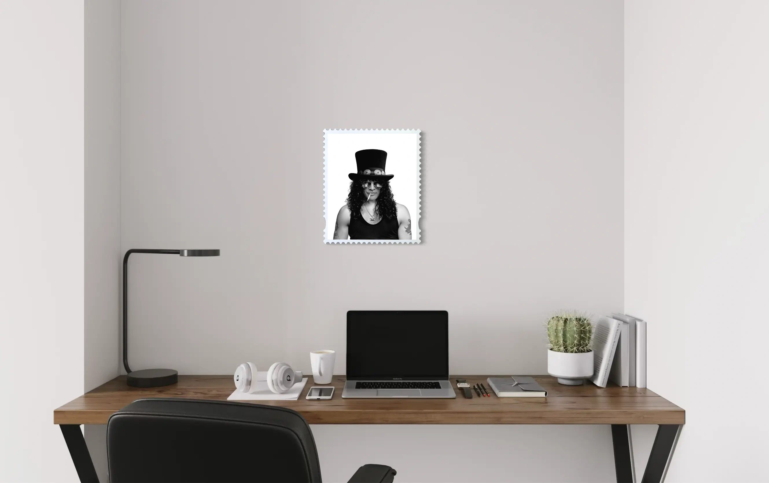 Slash Skin & Bones lenticular stamp artwork mounted on a light neutral wall above a minimal wooden desk with a laptop, headphones and cactus – portrait state shown. #size_medium